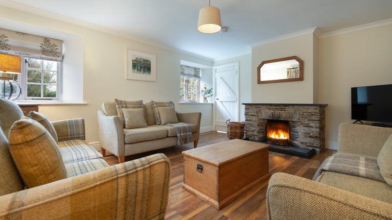 The sitting room with open fire at Roseland Porth Barn, Cornwall